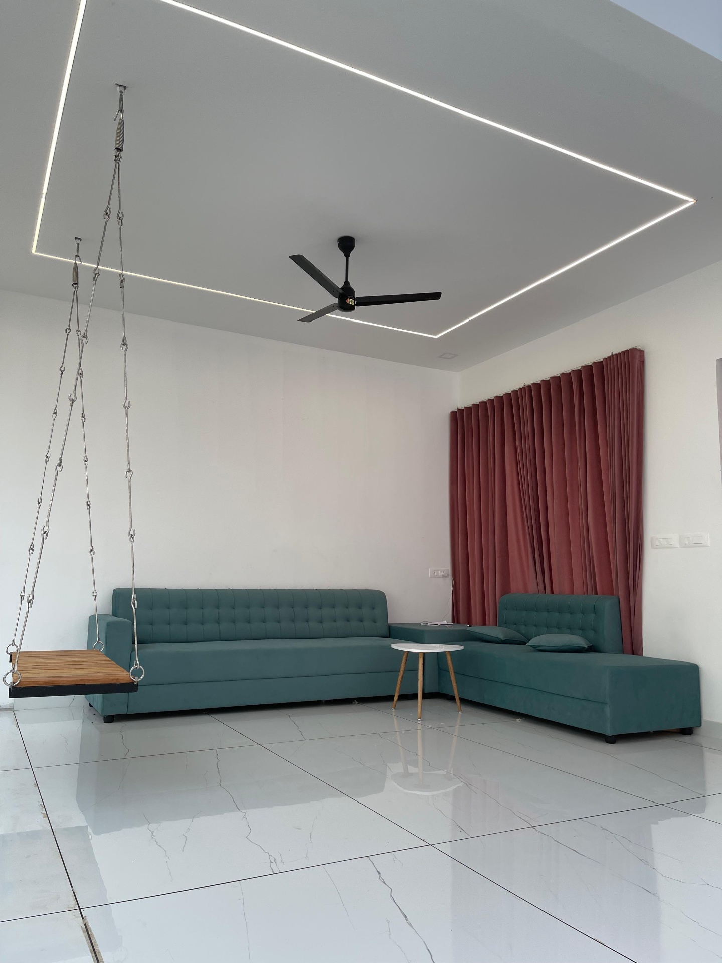 Modern living room interior with recessed LED ceiling detail, teal tufted sofa and marble flooring by iptnirman